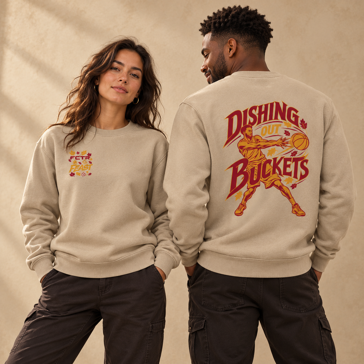 Adult models wearing the Desert Dust FCTR Feast Dishing Out Buckets sweatshirt, showing the front chest logo and back basketball graphic