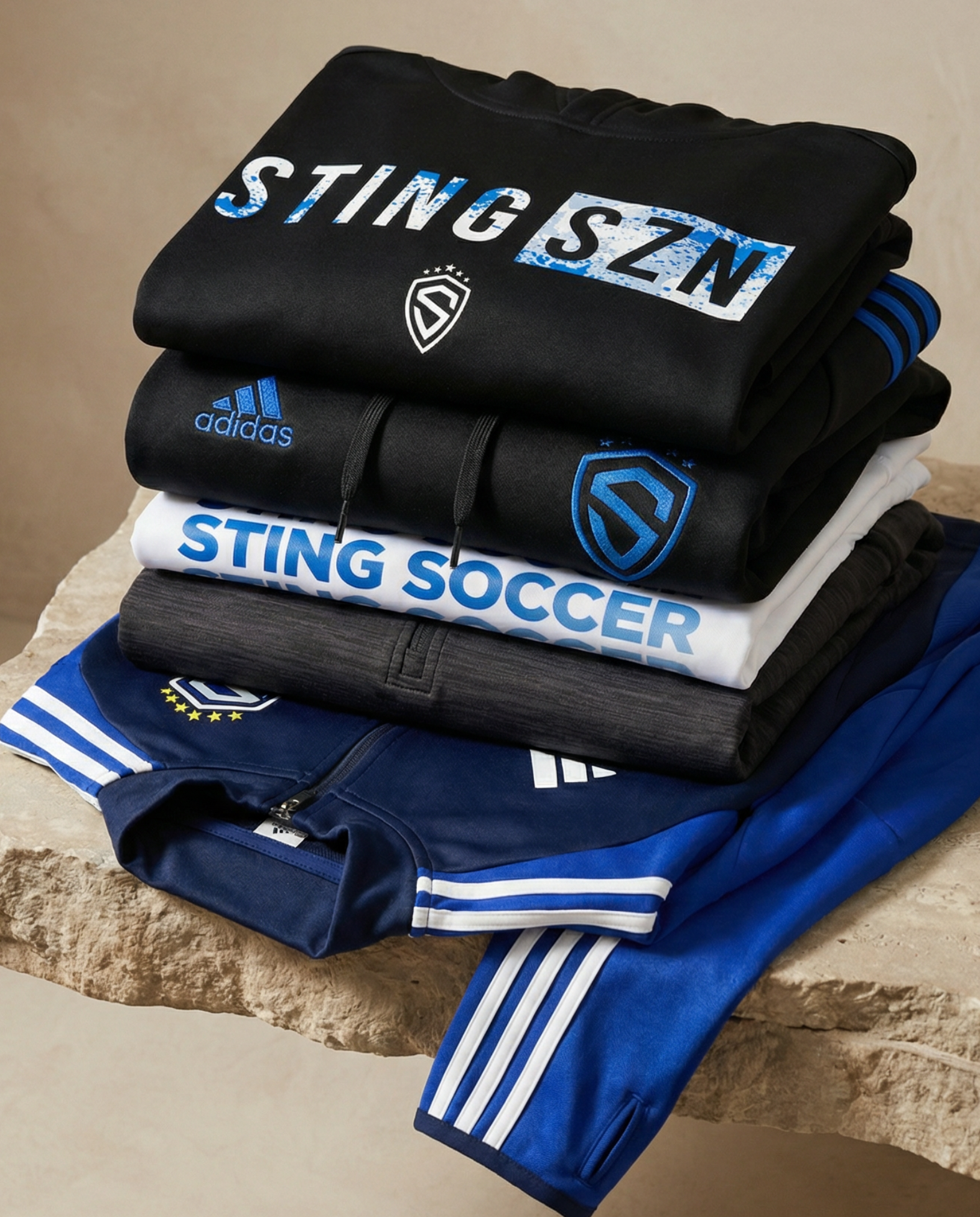 Stack of folded sports jerseys with visible branding on a stone surface.